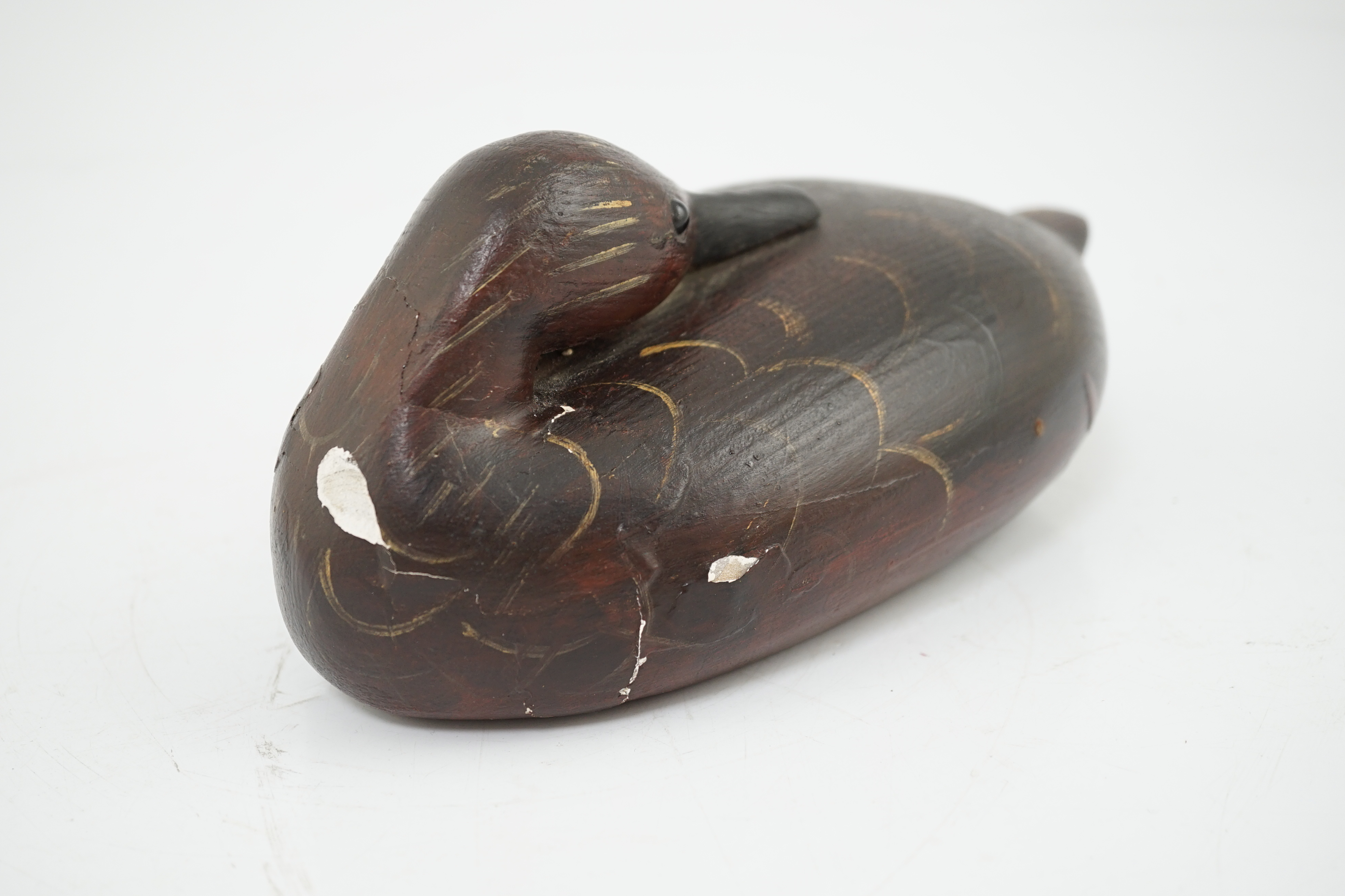 Manner of Guy Taplin (British, b.1939), a carved and painted oak model of a duck with glass inset eyes, 27cm long